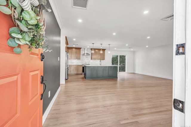 foyer with crown molding and light hardwood / wood-style flooring