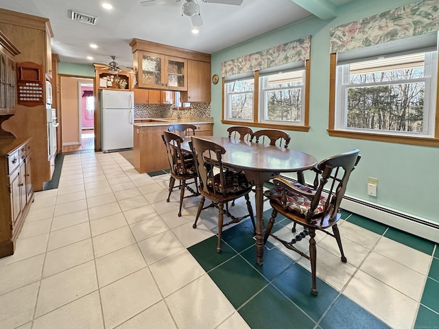 tiled dining area with ceiling fan