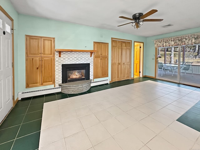 unfurnished living room featuring ceiling fan, baseboard heating, tile patterned floors, and a tile fireplace