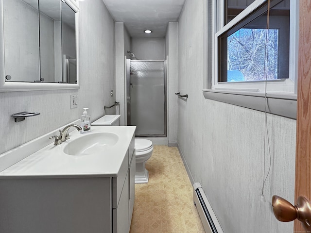 bathroom featuring toilet, vanity, a shower with door, and a baseboard radiator