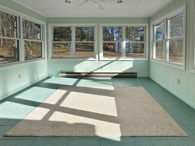 unfurnished sunroom with a baseboard heating unit and ceiling fan