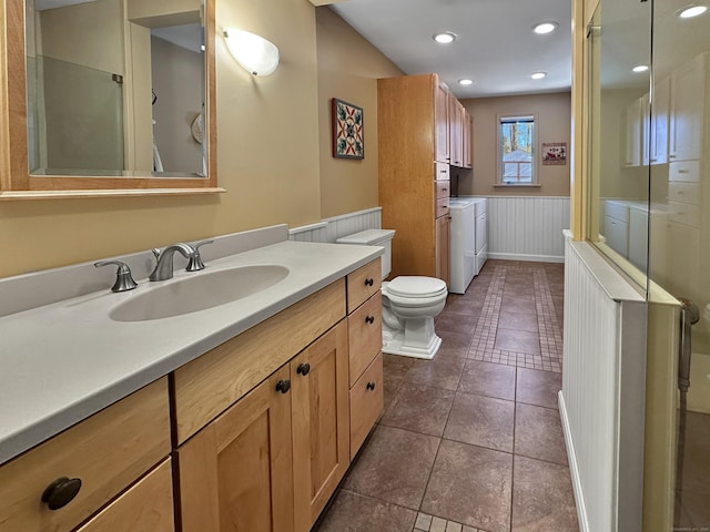 bathroom with toilet, washer and dryer, tile patterned flooring, and vanity