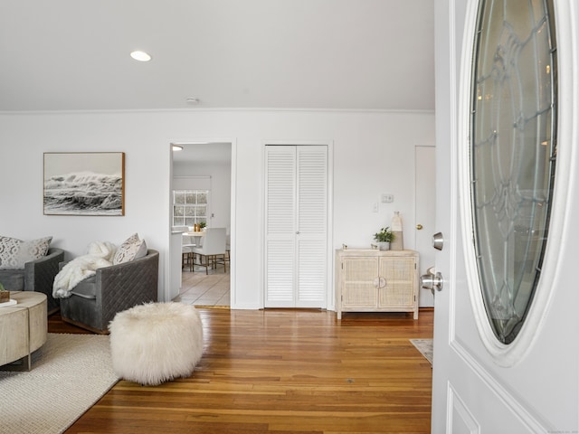 entrance foyer with light hardwood / wood-style floors and crown molding