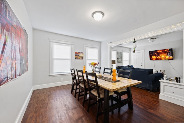 dining space featuring dark wood finished floors and baseboards