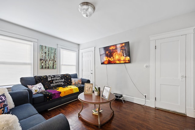 living room featuring dark wood-type flooring and baseboards