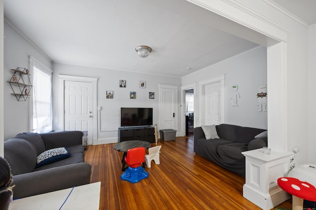 living area featuring dark wood finished floors and crown molding