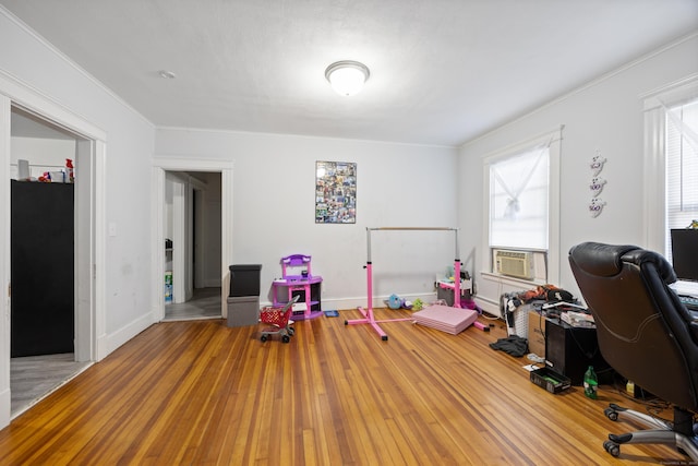 office space with ornamental molding, cooling unit, baseboards, and wood finished floors