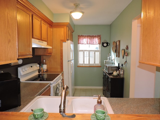 kitchen featuring white appliances, tile patterned flooring, and sink