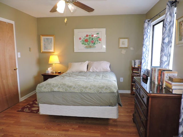 bedroom with multiple windows, ceiling fan, and dark hardwood / wood-style floors