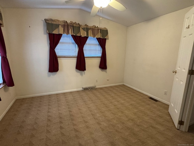 empty room featuring ceiling fan, lofted ceiling, and carpet floors