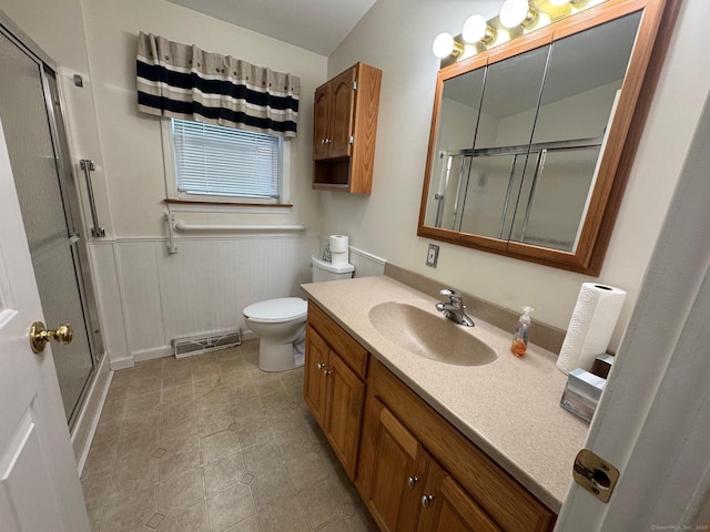 bathroom with vanity, a shower with shower door, and toilet