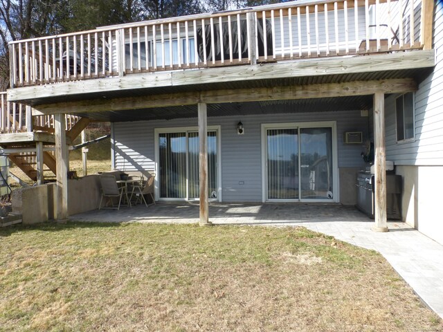 back of property with a wooden deck, a yard, and a patio