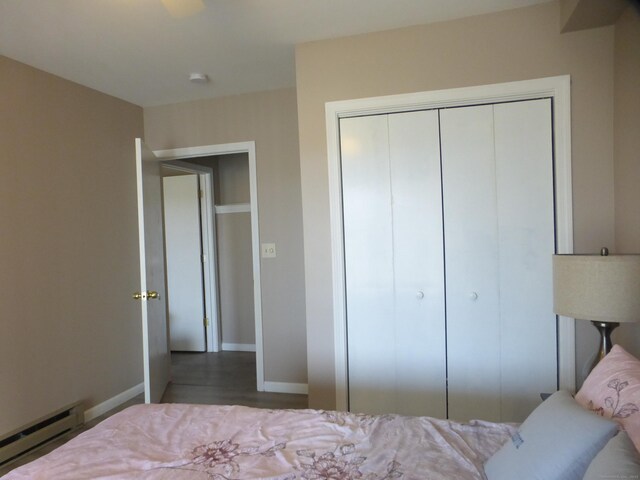 bedroom featuring a baseboard radiator and a closet