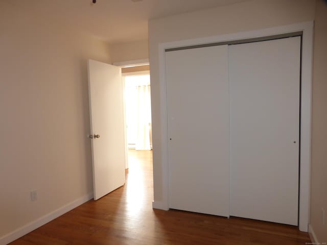 unfurnished bedroom with a closet and light hardwood / wood-style floors