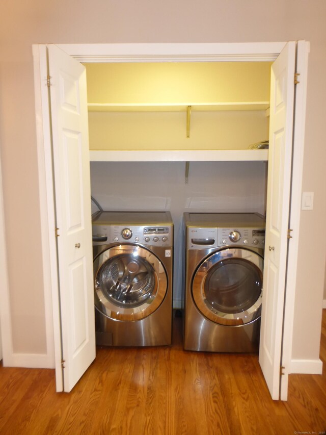 laundry room with washer and clothes dryer and wood-type flooring