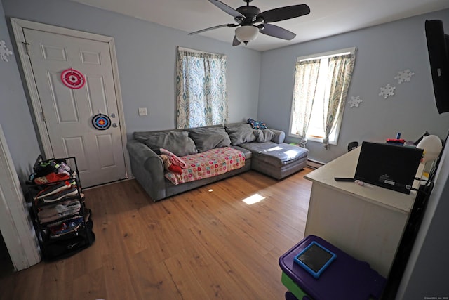 living room featuring a baseboard radiator, ceiling fan, and hardwood / wood-style flooring