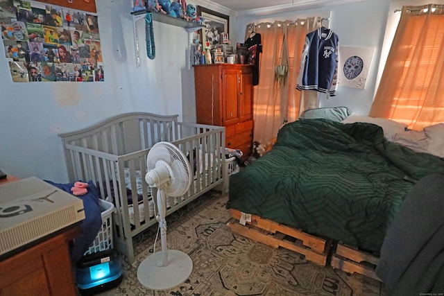 bedroom with a nursery area and crown molding