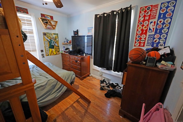 bedroom featuring ceiling fan, hardwood / wood-style flooring, and crown molding