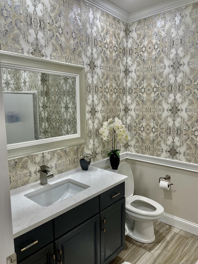 bathroom with ornamental molding, hardwood / wood-style floors, vanity, and toilet