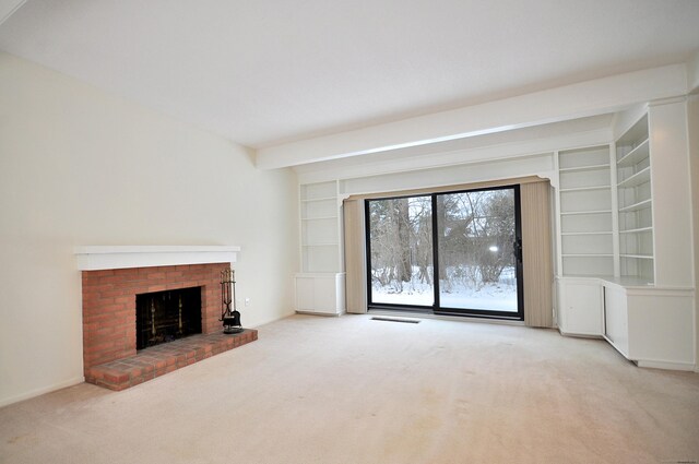 unfurnished living room featuring built in shelves, light colored carpet, a brick fireplace, and beamed ceiling