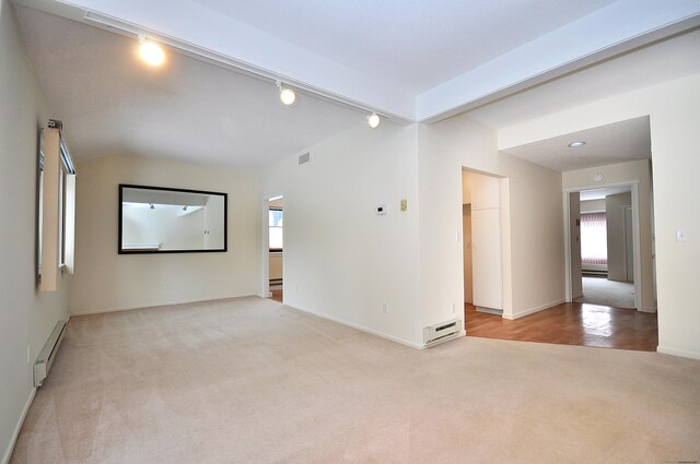 unfurnished room with a baseboard radiator, a healthy amount of sunlight, track lighting, and light carpet