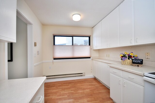 kitchen featuring stove, light hardwood / wood-style flooring, white cabinets, and baseboard heating