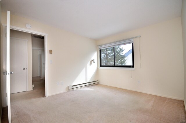 carpeted empty room featuring a baseboard radiator