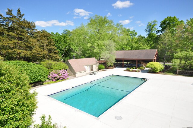 view of swimming pool featuring an outdoor structure and a patio