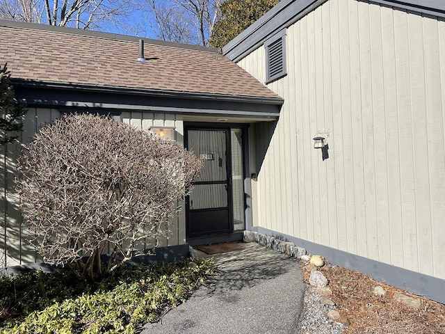 doorway to property with a shingled roof