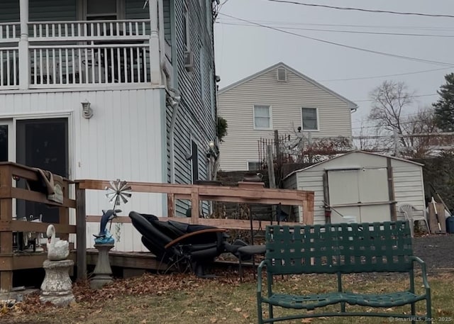 back of property with a wooden deck and a storage shed