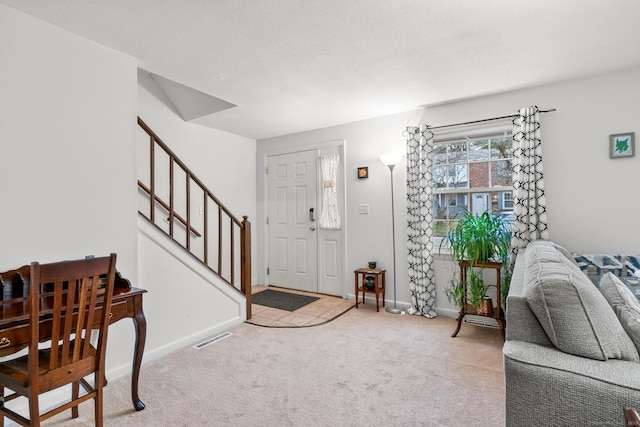 entryway with baseboards, visible vents, carpet flooring, and stairs