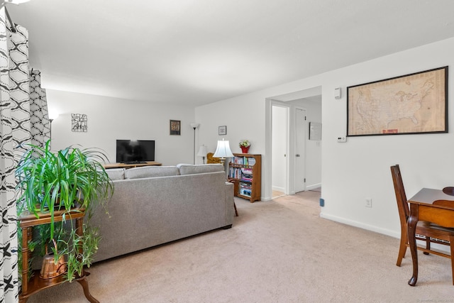 carpeted living room featuring baseboards