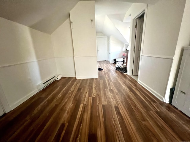 additional living space with dark hardwood / wood-style flooring, vaulted ceiling, and a baseboard heating unit