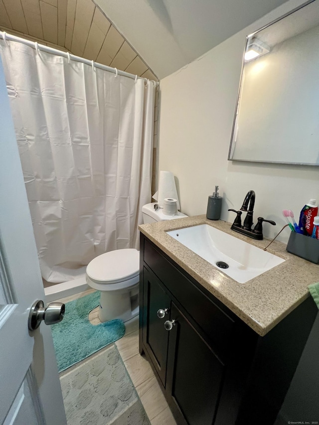 bathroom with toilet, vanity, and walk in shower