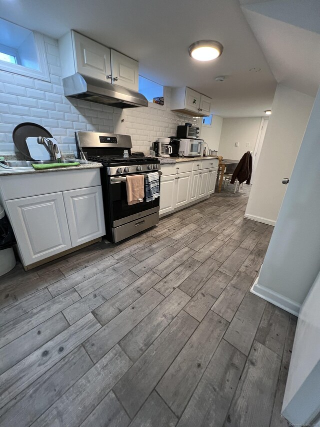 kitchen featuring stainless steel appliances, white cabinets, and tasteful backsplash