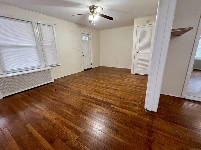 interior space with ceiling fan, dark hardwood / wood-style flooring, and radiator