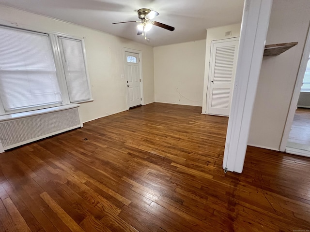 entryway with dark wood-type flooring, radiator heating unit, and ceiling fan