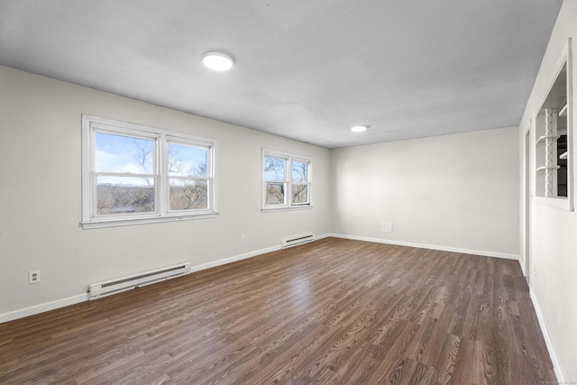 unfurnished room with a baseboard heating unit and dark wood-type flooring