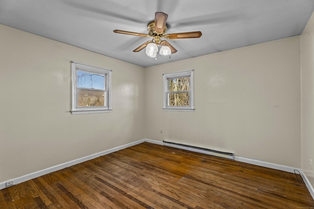 spare room with ceiling fan, dark hardwood / wood-style floors, and a baseboard heating unit