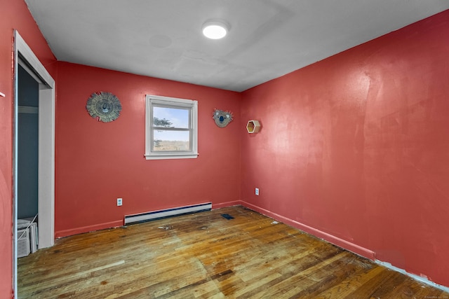 unfurnished room featuring wood-type flooring and baseboard heating