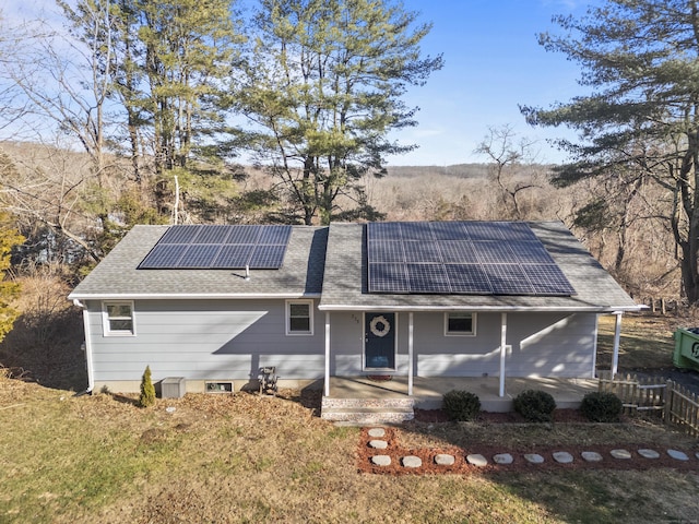 rear view of property featuring solar panels