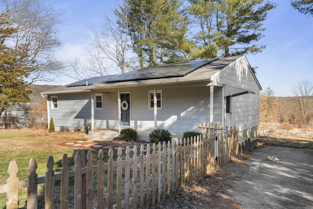 ranch-style home featuring covered porch and solar panels