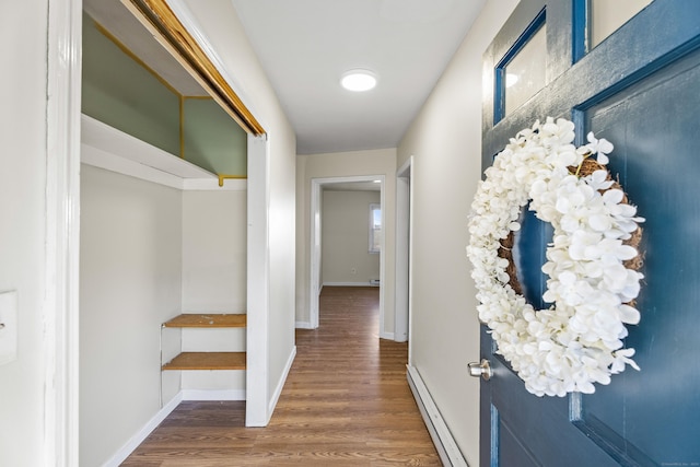 hallway with baseboard heating and dark wood-type flooring