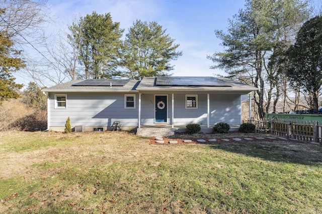 ranch-style home with solar panels and a front lawn