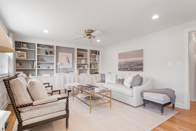 living room with ceiling fan, hardwood / wood-style floors, and built in shelves