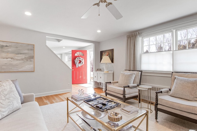 living room with light hardwood / wood-style floors, radiator heating unit, and ceiling fan