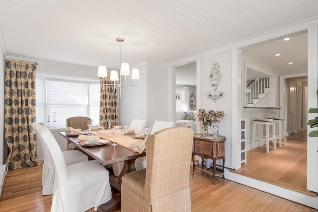 dining area featuring light hardwood / wood-style floors, wooden ceiling, ornamental molding, and an inviting chandelier