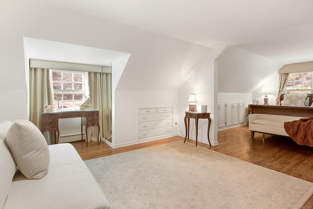 bedroom featuring a baseboard radiator, hardwood / wood-style floors, and vaulted ceiling