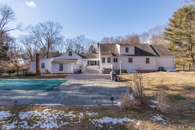 back of house with a pool side deck and a patio