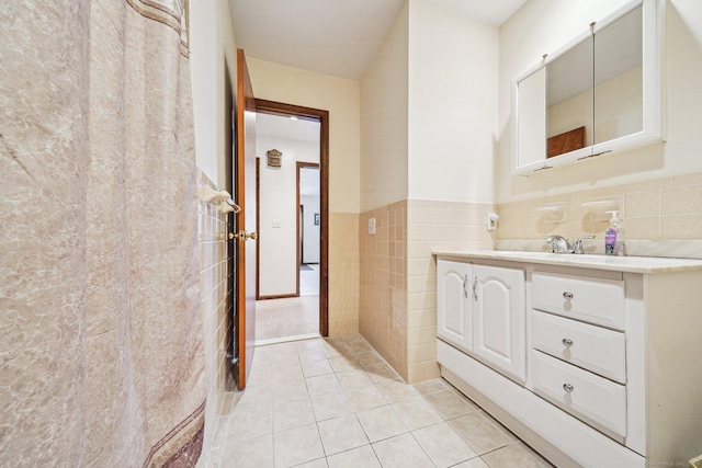 bathroom with tile walls, vanity, and tile patterned floors